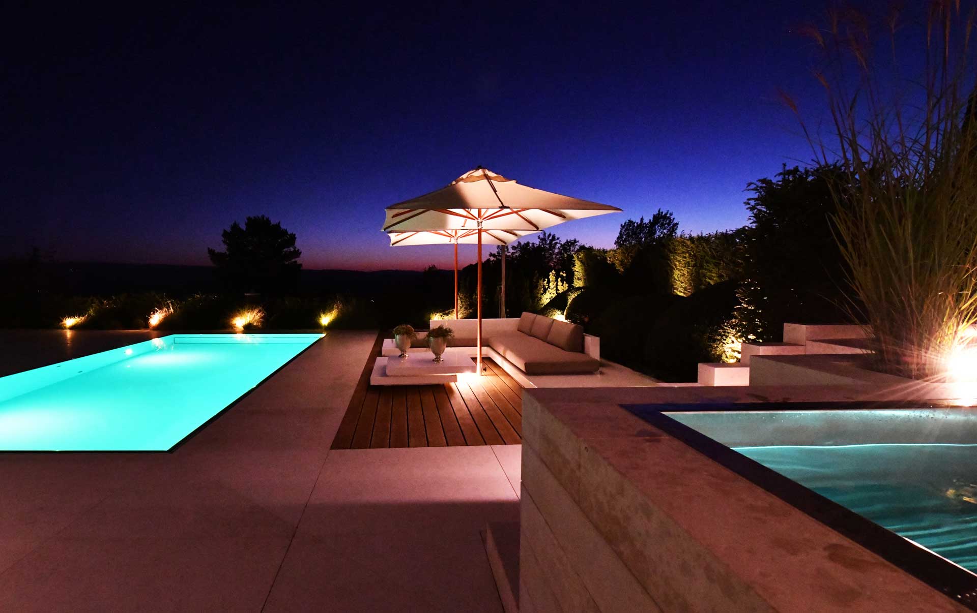 Mit Megaspot Pool beleuchteter Pool, auf einer Terrasse mit Sitzecke zum entspannen